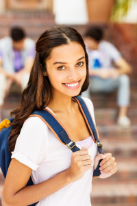 Female Student Carrying Backpack With Students In Background