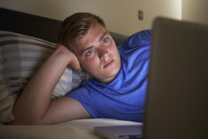 Teenage Boy Using Laptop In Bed At Night